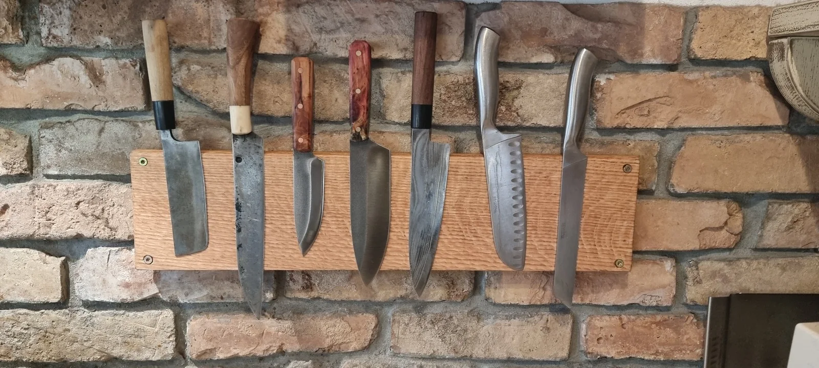 An oak magnetic knife rack made by Peter; his knives are the third and fourth from the left.
