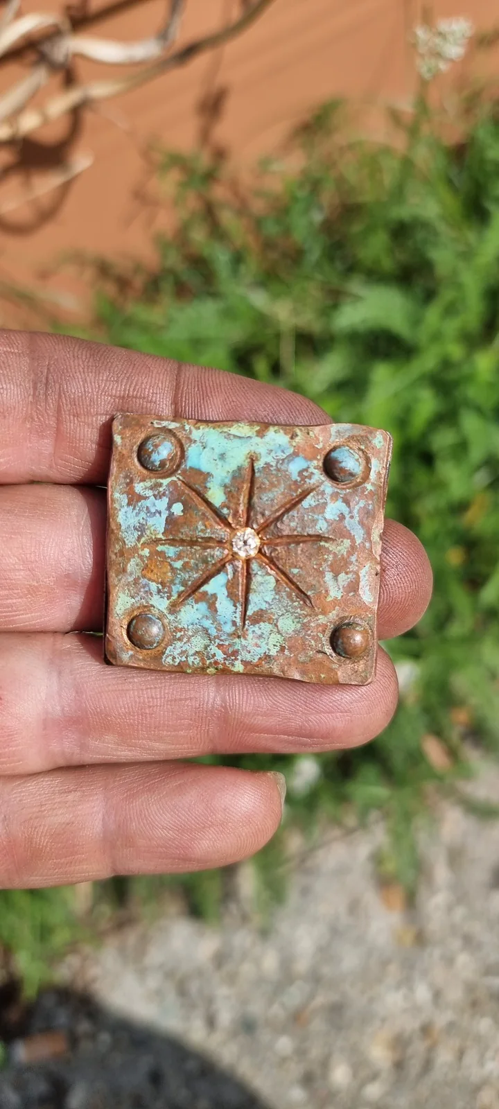 The patinated Blacksmith’s Star, with eight rays, corner rivets and a clear central stone.